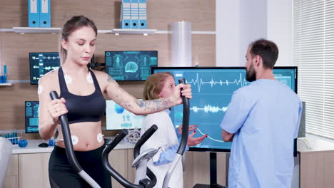 female doctor in sport science checking the energy of female athlete on tv monitor