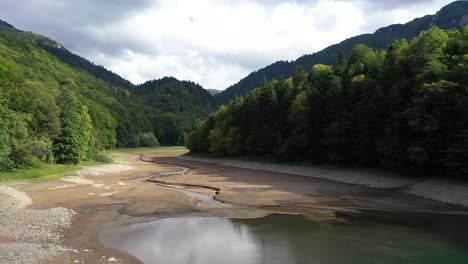 aerial - from the lake, following the flow of the river, going between trees