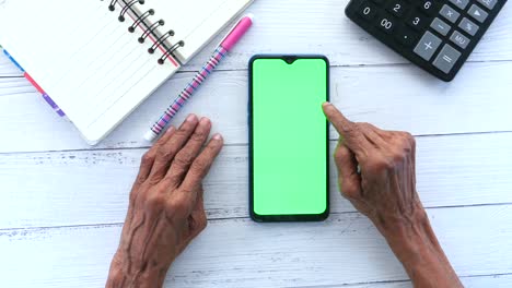 mujeres mayores mano usando teléfono inteligente en la mesa