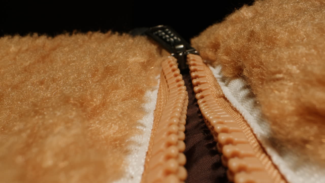 Footer textile cloth texture close-up macro. Jacket with zipper Fashion fabric multicolor. Sheep wool for clothes