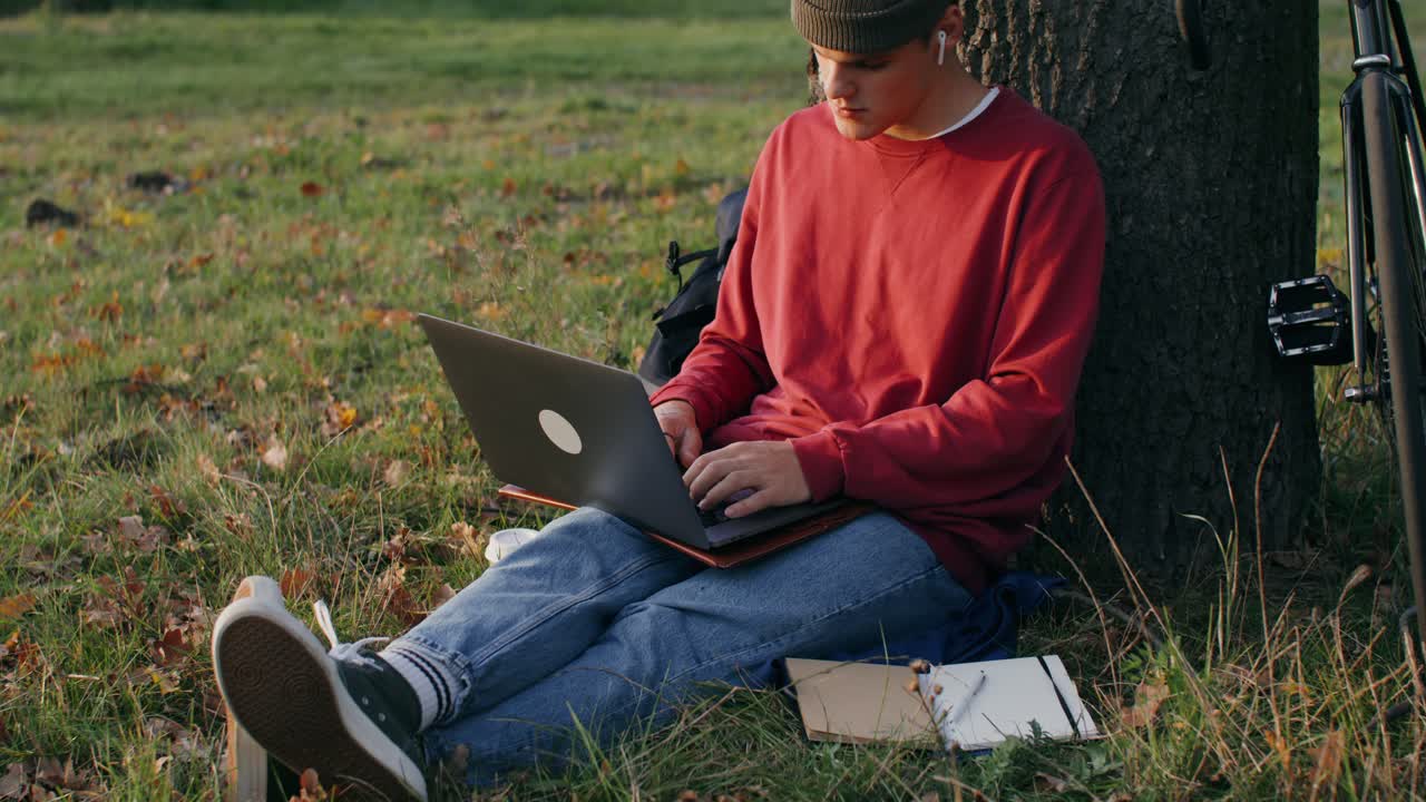 hombre trabajando en una computadora portátil en un parque