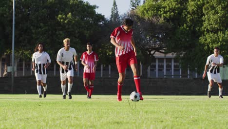 video of diverse group of male football player on field, playing football