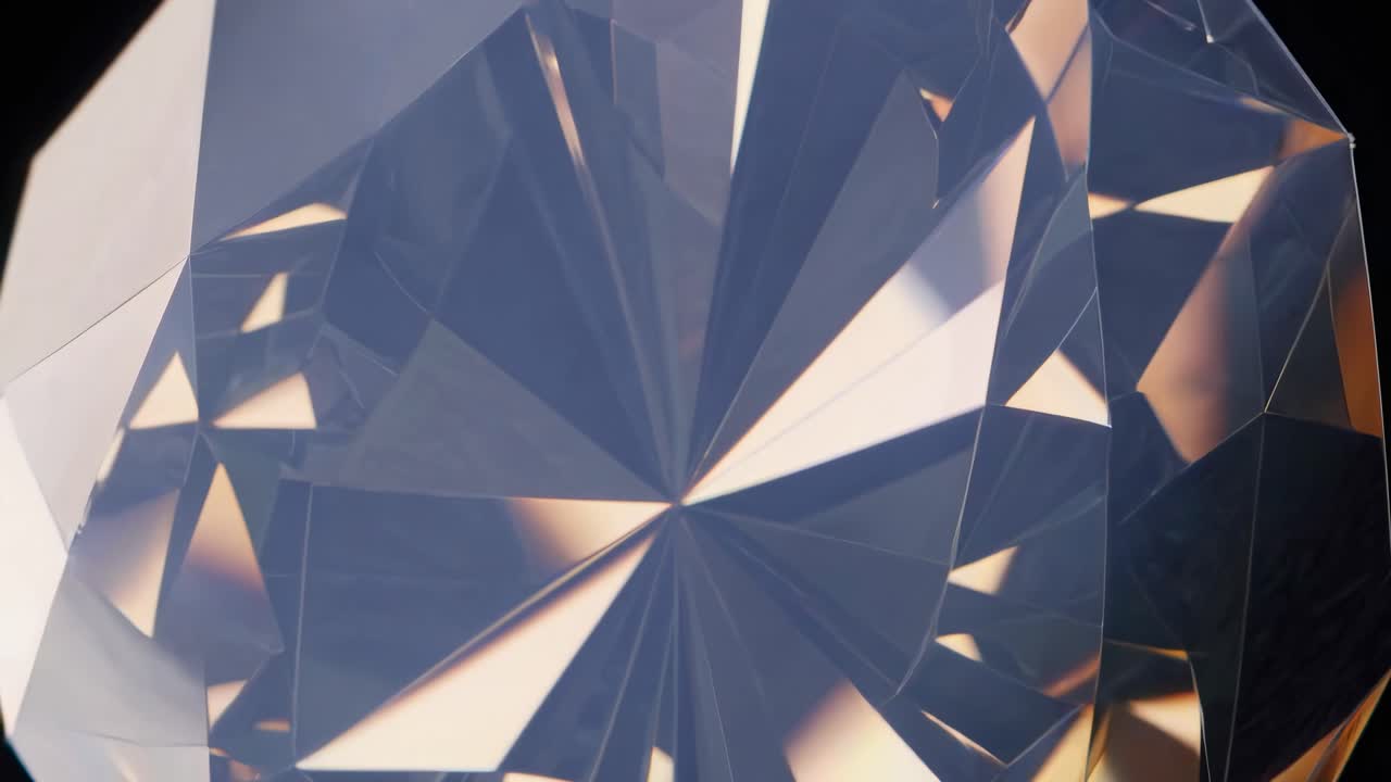 Close-up video of a rotating, multifaceted gemstone reflecting warm light, shot from a low angle