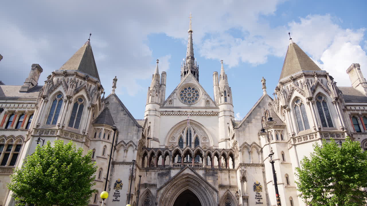 Front view of the main entrance of the Royal Courts of Justice in London, England under a clear blue sky