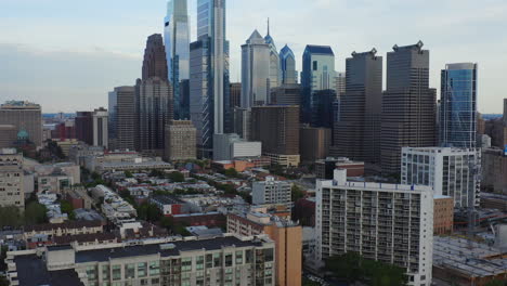 aerial drone revealing the philadelphia city skyline showcasing comcast technology center and tall east coast skyscrapers and buildings from schuylkill river trail