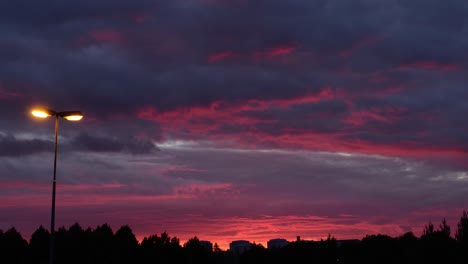 nubes de color rojo vívido que se mueven rápidamente durante la puesta del sol