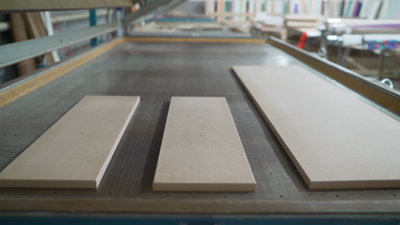 los espacios en blanco de los muebles antes de aplicar la película. fabricación de muebles. espacios en blanco para muebles de madera están en la máquina. industria del trabajo de la madera. taller de muebles un taller para la producción de productos de madera.