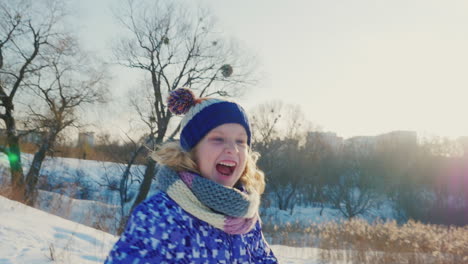 the child runs through the snow and rejoices in the winter day