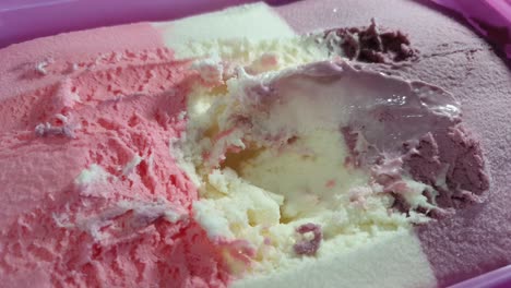 helado a rayas con tema de barbie con sabor a fresa, vainilla y corriente negra en tina rosa, delicioso postre dominical servido con una cuchara de acero inoxidable