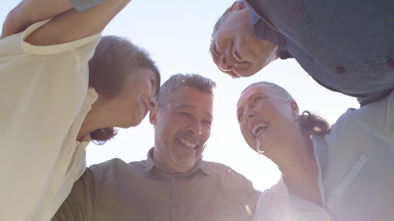 Laughing and embracing, senior friends enjoying time together outdoors