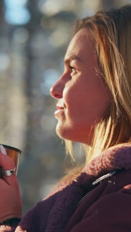 woman enjoying a warm drink outdoors in winter