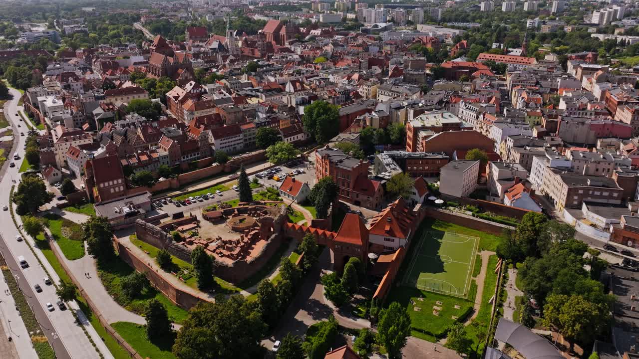 Cinematic aerial flight shows Torun old town and fortress ruins in vivid detail