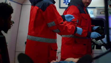 Paramédicos-Preparando-Desfibrilador-Para-Ayuda-Médica.-Doctores-Reanimando-Al-Hombre