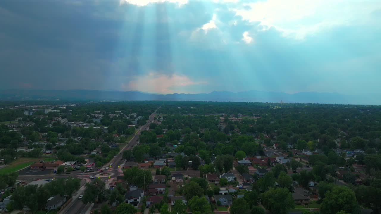 Summer sun rays Lakewood Sloans Lake Park downtown Denver spring Colorado aerial drone blue skies dark rain clouds sunlight neighborhood homes Coflax Sherdian cars traffic forward motion