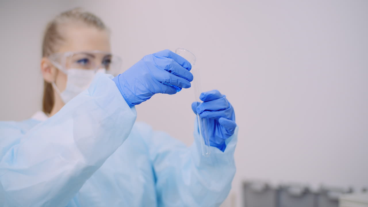 científica femenina sosteniendo tubos y matraz con líquido en las manos 1