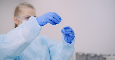 Female-Scientist-Holding-Tubes-And-Flask-With-Liquid-In-Hands-1