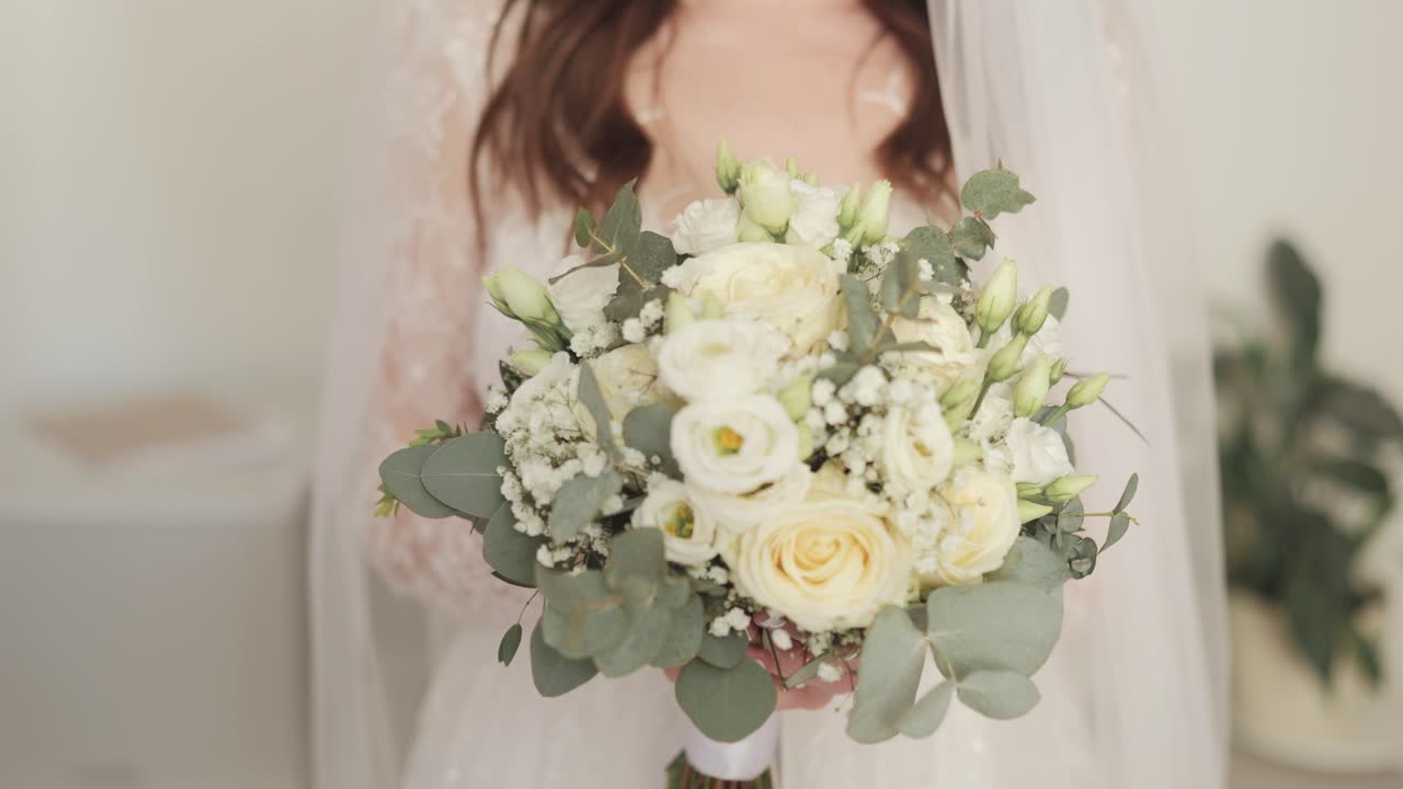Sposa che tiene in mano un bellissimo bouquet floreale bianco il giorno del matrimonio
