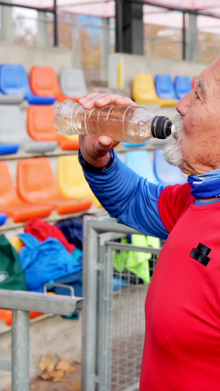 Senior Man Hydrating at Stadium