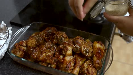 seeds being sprinkled over freshly cooked chicken meat