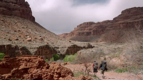 mochileros caminando a un campamento de campo en el cañón del desierto en el suroeste de arizona