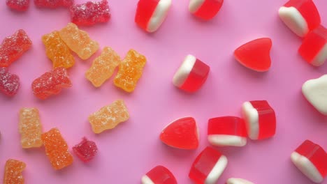 assorted gummy candy on pink background