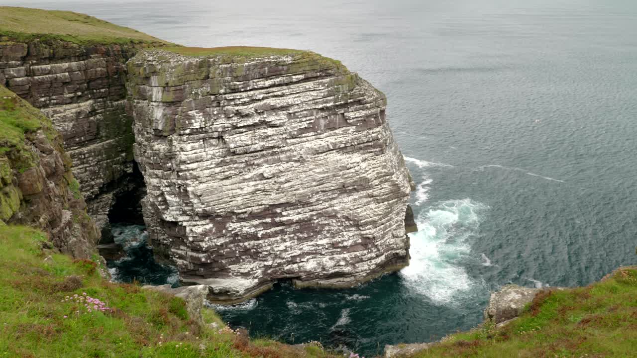 vista panorámica de un acantilado marino y la gran pila de mar de la isla de handa cubierta por una bulliciosa colonia de aves marinas llenas de poblaciones reproductoras de papagaios, guillemots, kittiwake y razorbills en escocia