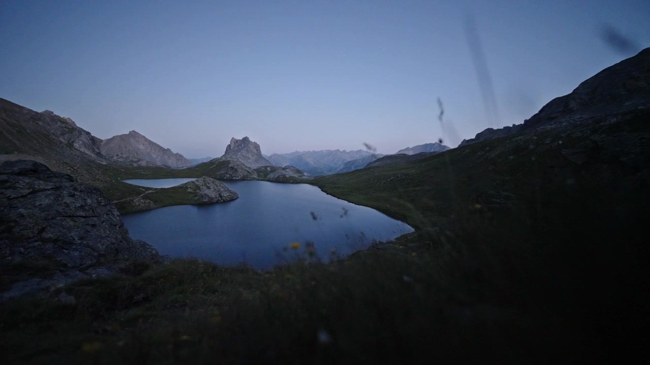 Il crepuscolo scende sul Lago Superiore di Roburent mentre l'acqua blu calma riempie la valle tra ripide creste