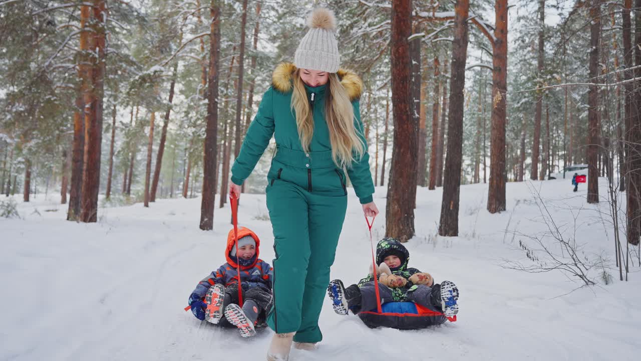 Mother and children sledding in a snowy forest