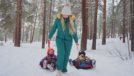 mother and children sledding in a snowy forest