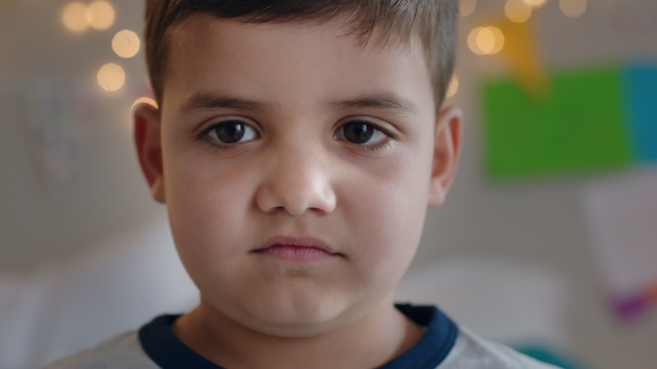 초상화 행복한 작은 소년은 카메라에 심각하게보고 집에서 귀여운 아이