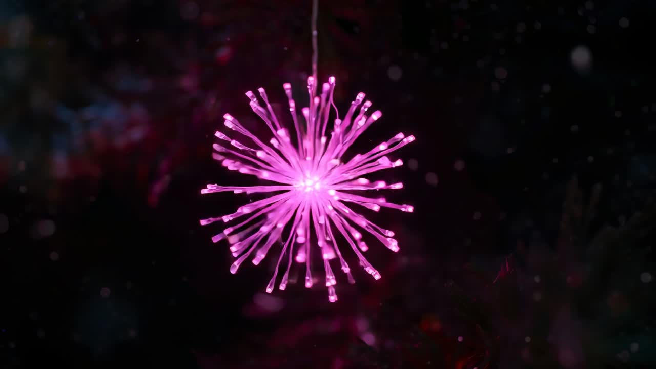 All'inizio della clip, ornamento a LED sferico e appuntito sospeso che pulsa in una stanza buia, con granelli fluttuanti