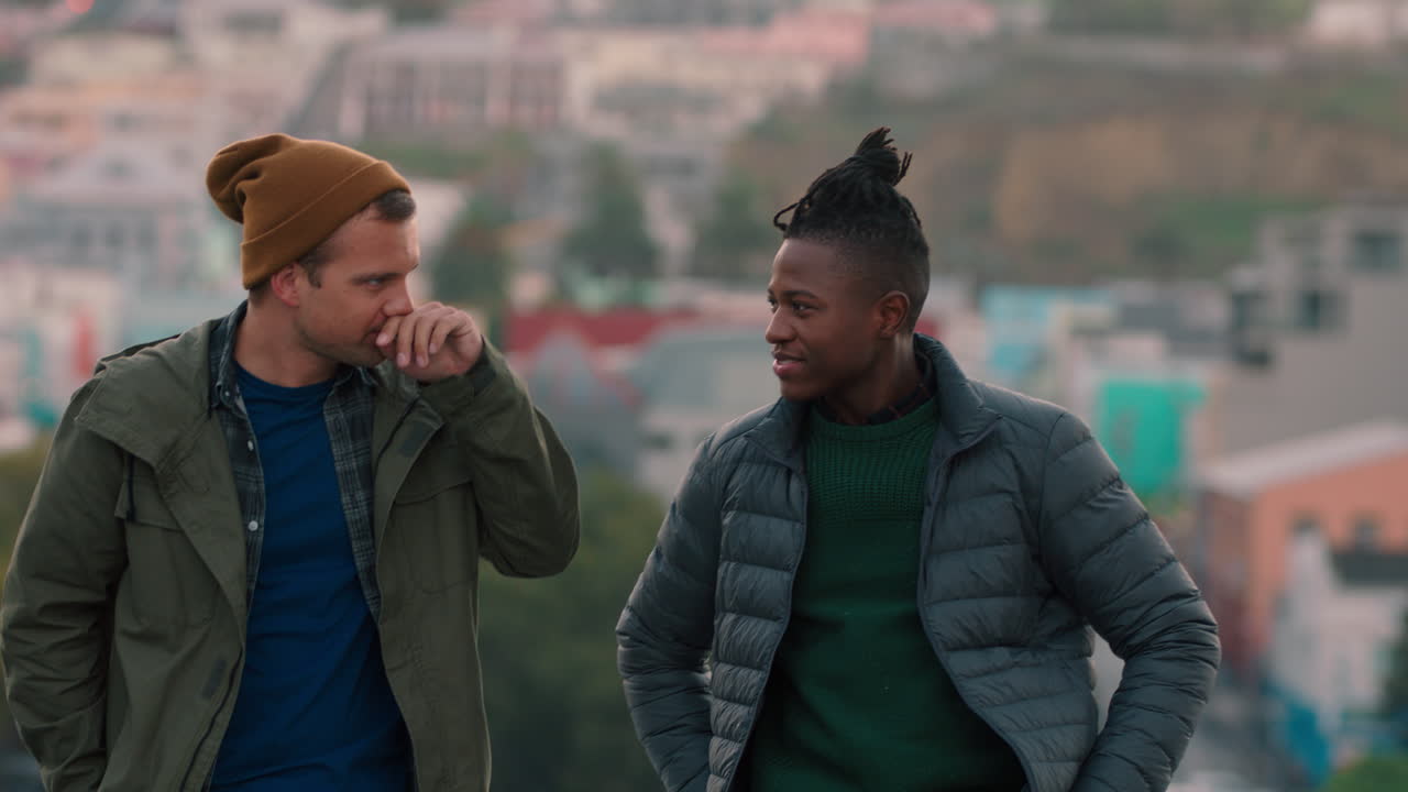 amigos felices charlando en la azotea disfrutando de la conversación pasando el rato compartiendo la vista del hermoso horizonte de la ciudad al atardecer