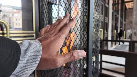 person warming their hand near a modern fireplace