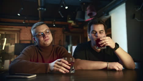 two friends enjoying drinks at a bar