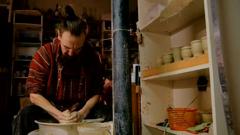 professional male potter working with clay on potter's wheel