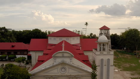 drone shot reveals the sea behind the beautiful panglao church in bohol, philippines