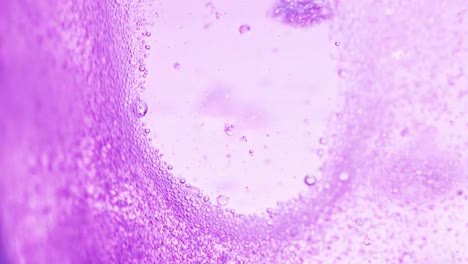 foto macro de agua violeta brillante con muchas burbujas brillantes dejando un pequeño lugar sin burbujas