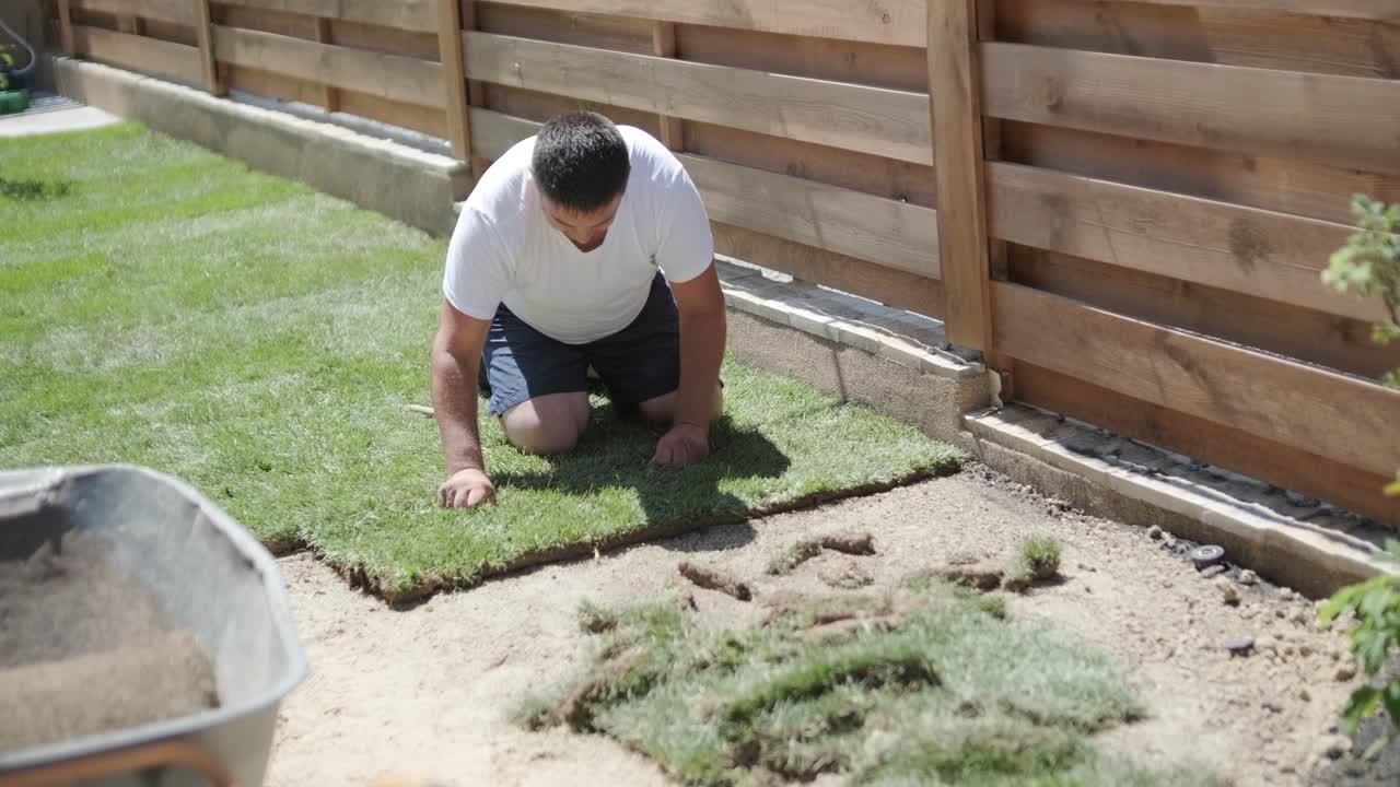 hombre colocando césped en el jardín del patio trasero para la instalación de césped y proyecto de jardinería, centrado en la mejora del hogar y el mantenimiento al aire libre para un césped fresco y verde en un patio residencial
