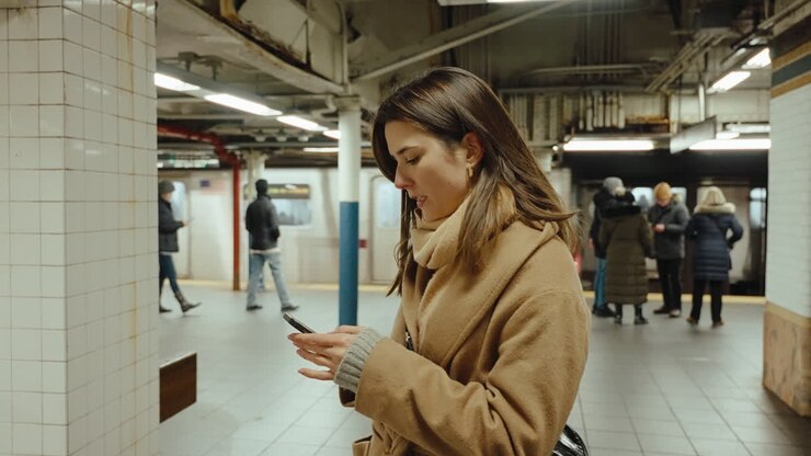 Woman using phone in NYC subway station