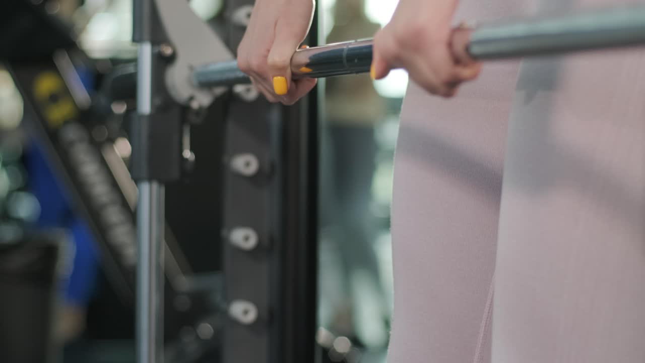 mujer de fitness en ropa deportiva haciendo cuclillas con pesas en las manos. entrenamiento en el gimnasio