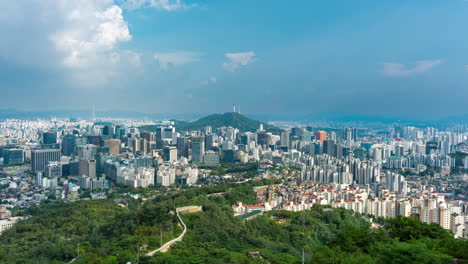 seoul city wall stretching down from inwangsan mountain, aerial cityscape time lapse with fluffy moving clouds above city panorama, namsan tower view, downtown business district skyscrapers