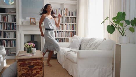 happy dancing woman celebrating achievement with victory dance having fun enjoying success wearing beautiful dress at home 4k