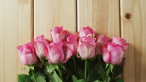 bouquet of pink roses on wooden background at valentine's day