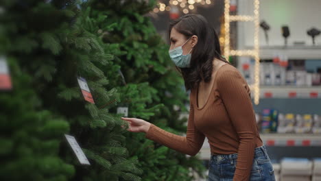 a woman in a protective mask in a jewelry store and garlands with toys for christmas trees and at home. christmas garlands and decor