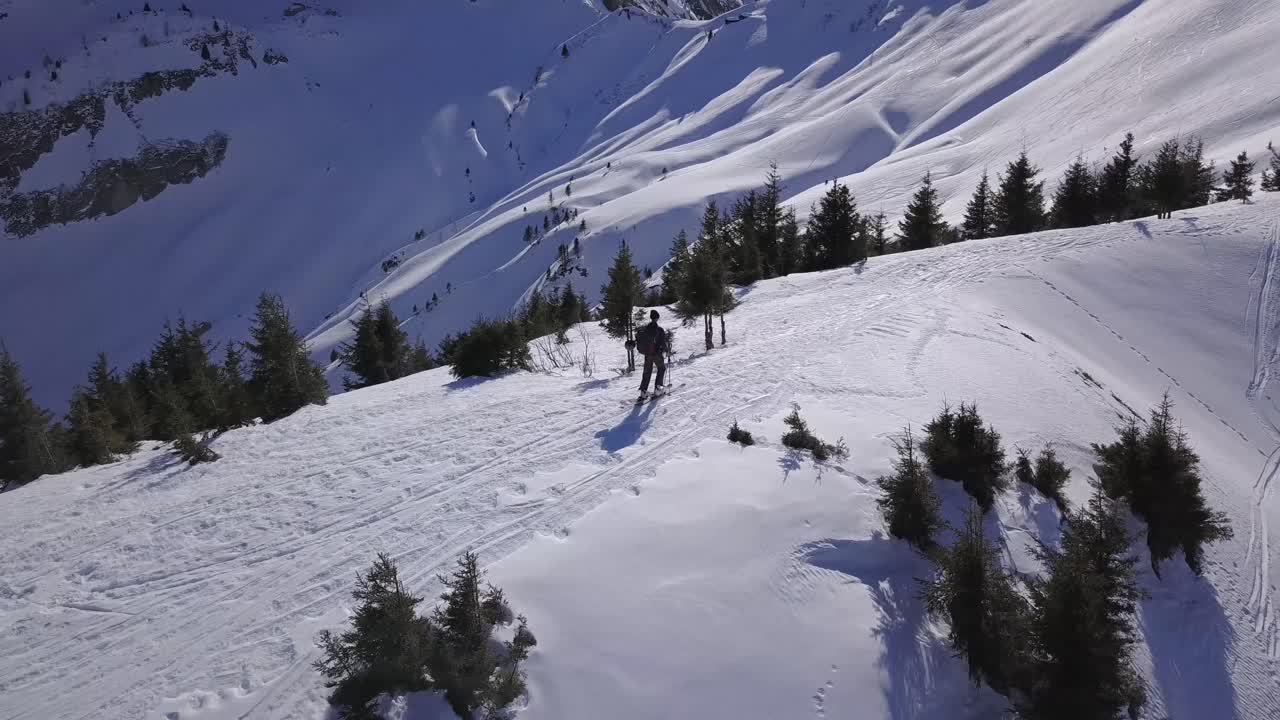 drone siguiendo skiier desollado en la cresta de la montaña
