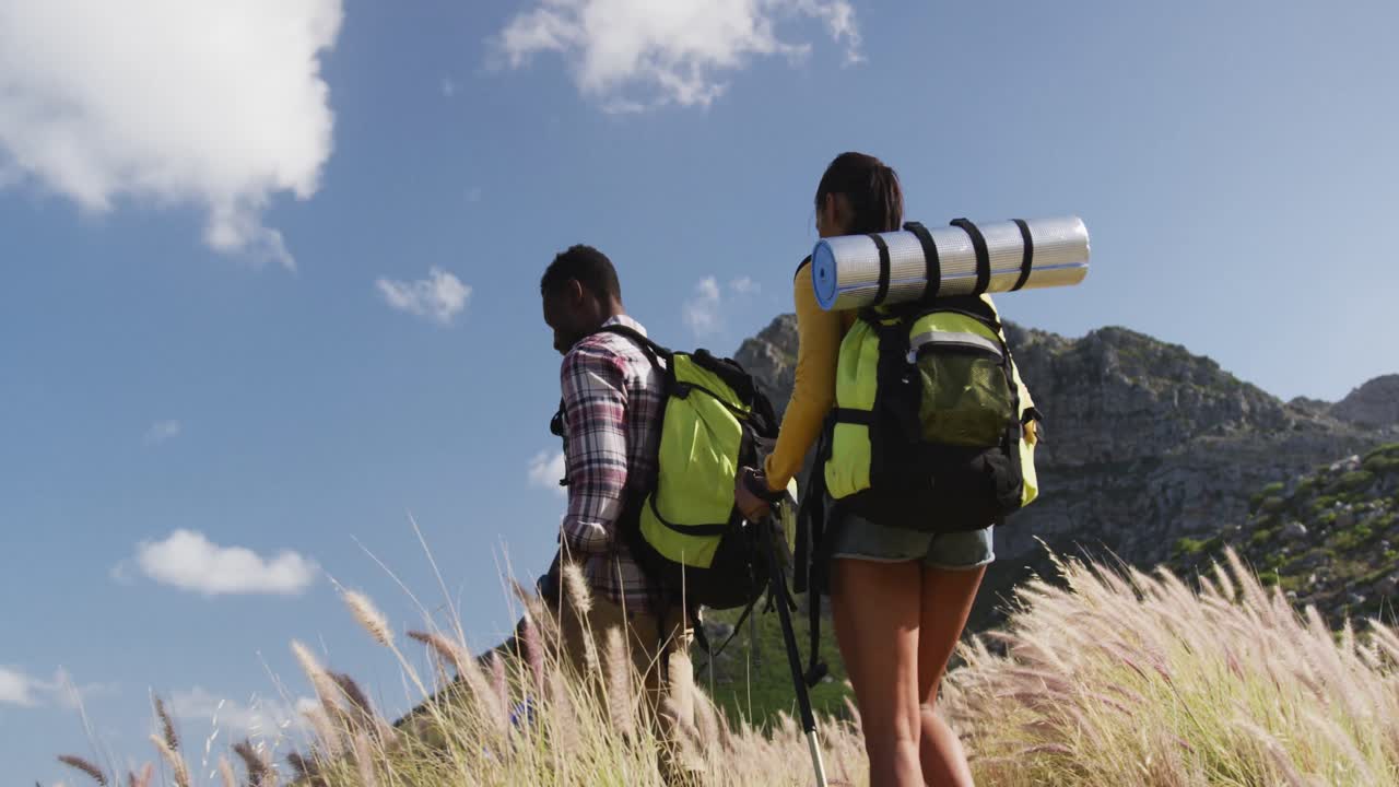 아프리카계 미국인 부부가 산에서 트레킹을 하는 동안  ⁇ 고 있습니다.