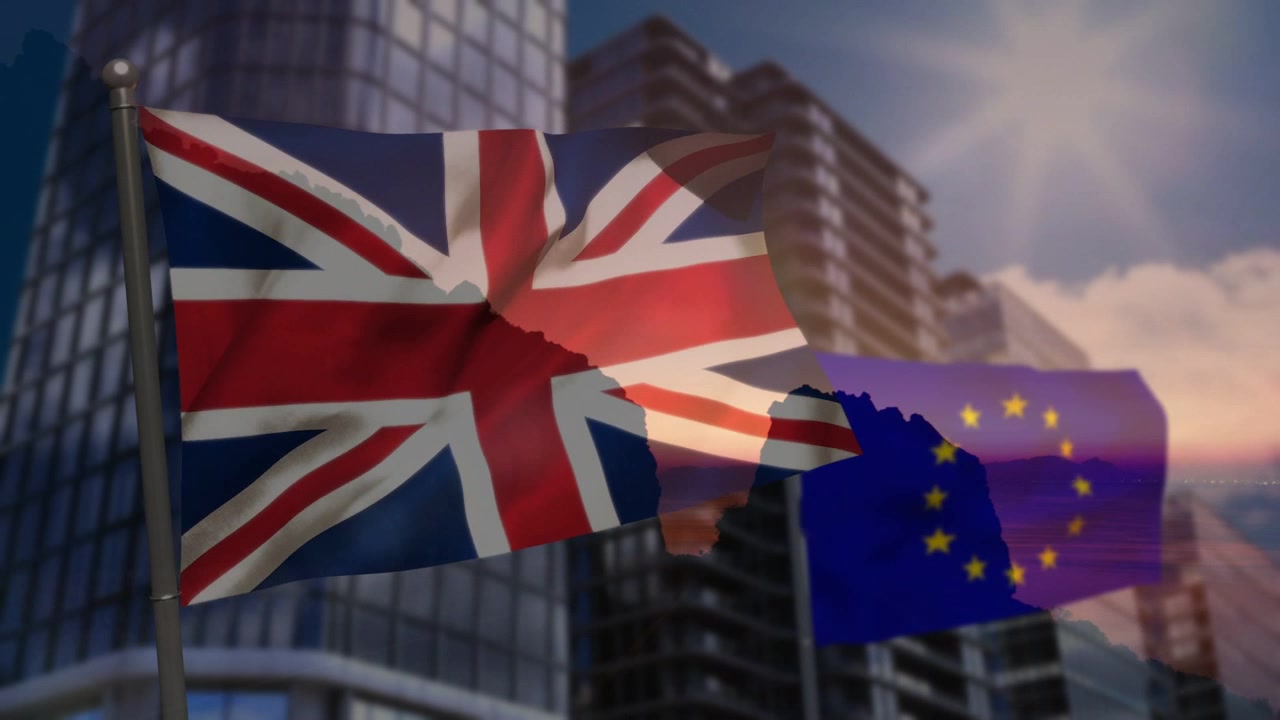 Strong breeze causing Union Jack unfurling while EU flag fluttering before glass high-rises