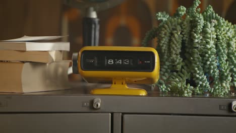 vintage yellow clock on a desk with succulent plant