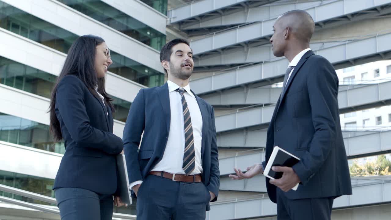 personas de negocios con dispositivos digitales hablando en la calle