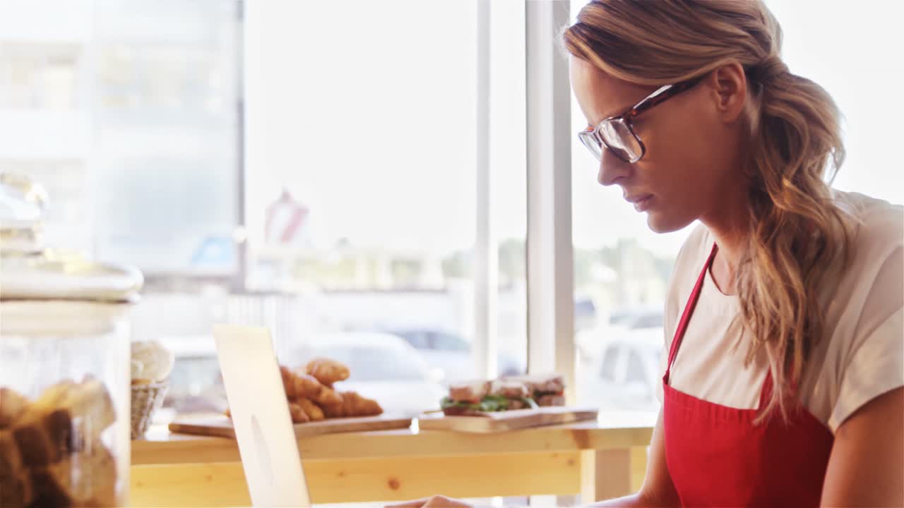 camarera cuidadosa usando una computadora portátil